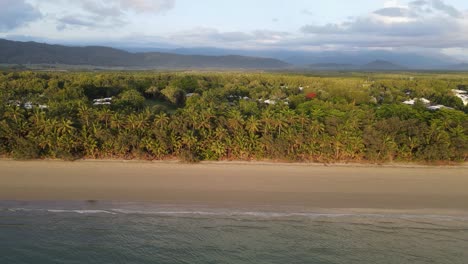 Palm-tree-lined-Four-Mile-Beach-and-the-rainforest-covered-mountain-ranges-of-the-Daintree
