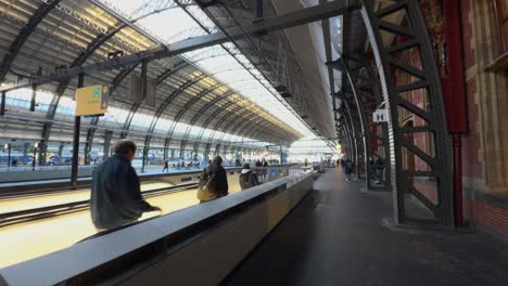 POV-Walking-Along-Station-Platform-Beside-Escalator-In-Amsterdam-Centraal-Station