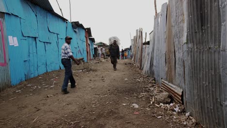 People-walking-on-a-narrow-path-in-a-slum