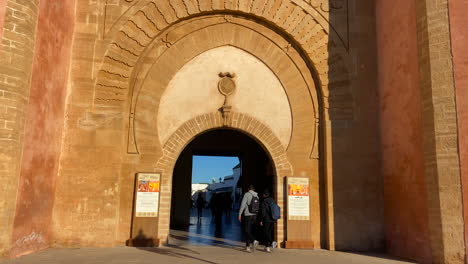 People-entering-the-Kasbah-of-the-Udayas-through-the-great-wall-gate-at-sunrise