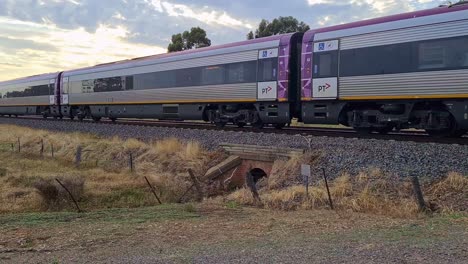 A-Vline-country-train-moving-through-a-railway-crossing-at-Chiltern-in-Victoria-Australia