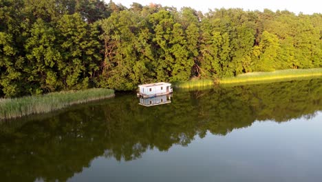 Hausboot-Schwimmt-Auf-Einem-See-Neben-Schilf-Bei-Sonnenuntergang-In-Brandenburg,-Deutschland