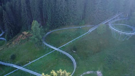 Drone-shot-of-bobsleigh-on-wheels-racing-down-from-the-hill-in-Swiss-mountains