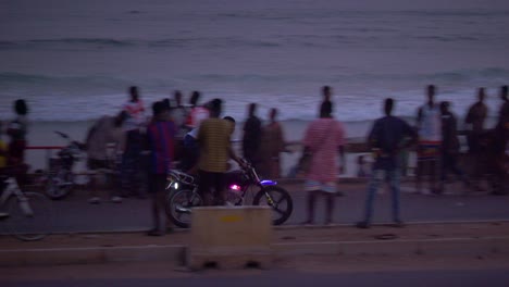 rider-making-acrobatic-on-motorcycle-on-raod-near-the-beach-with-traffic-and-pedestrian