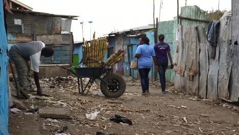 Hombre-Trabajando-Y-Cargando-Una-Carretilla-En-Un-Barrio-Pobre-De-Kenia