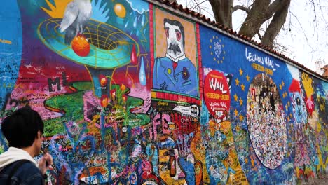 Turista-Visitando-El-Muro-De-Lennon-En-Praga,-República-Checa