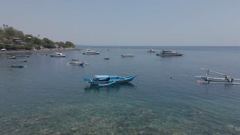 Flyover-outrigger-boats-moored-off-Jemeluk-pebble-beach-on-Bali