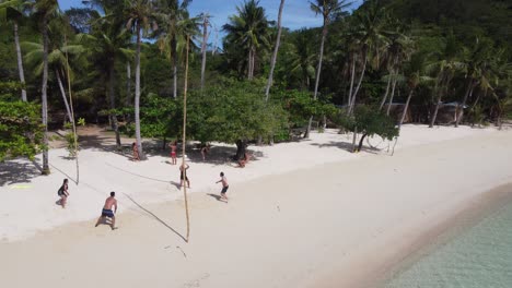 Jóvenes-Turistas-Jugando-Voleibol-En-La-Playa-De-Arena-Tropical-En-Un-Día-Soleado