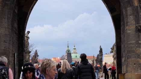 Tourists-entering-on-the-Charles-Bridge-in-Prague,-Czech-Republic