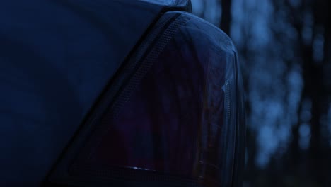 Close-up-sedan-car-flashing-hazard-warning-lights-abandoned-at-night-on-remote-road