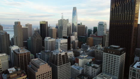 Drone-shot-rising-between-high-rise,-sunny-morning-in-San-Francisco,-USA