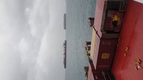 Containers-on-cargo-ship,-other-ships-in-distance,-Panama-Canal,-vertical