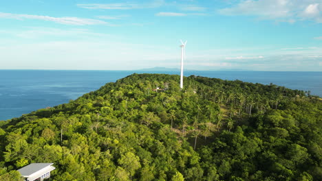 Aerial-flyover-beautiful-peaceful-vibrant-green-hill-with-a-windmill-on-top-of-Koh-tao,-thailand