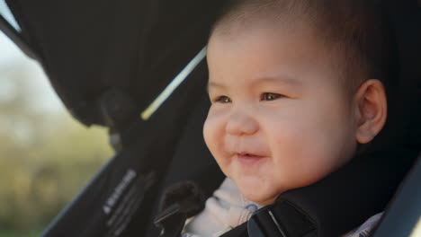 Goofy-Asian-baby-laughing-and-smiling-in-a-stroller