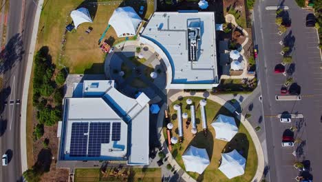 Overhead-aerial-shot-of-buildings-with-Solar-panels-on-roof-and-white-dome-tents-ready-for-event