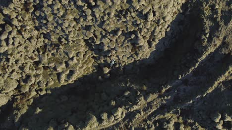 Luftaufnahme-Von-Oben-Nach-Unten-Eines-Paares,-Das-In-Lavafeldern-In-Island-Liegt