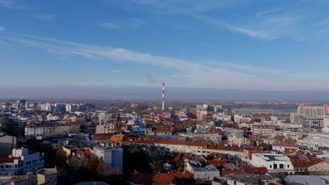 Aerial-footage-flying-towards-a-smokestack-in-Belgrade,-Serbia-on-a-sunny-day