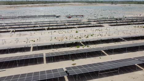 Aerial-tour-over-huge-photovoltaic-power-plant-with-new-solar-panels-under-construction-in-Jambur,-Gambia
