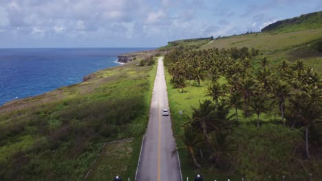Drone-shot-of-a-car-moving-along-Banzai-cliff,-Tinian-island