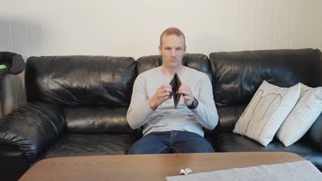 Man-sitting-in-sofa-showing-empty-wallet,-sad-because-of-no-money-60-fps