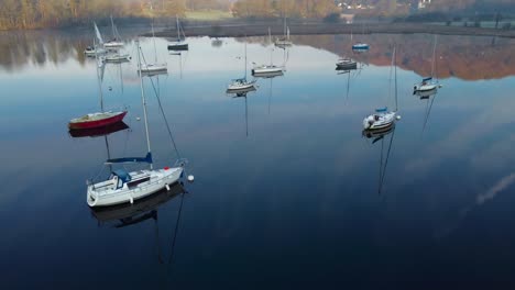 Small-sailing-boats-on-a-clear,-still-Spring-morning-in-Ambleside,-Windermere---Lake-District,-UK