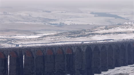 Long-Lens-Establishing-Aerial-Drone-Shot-of-Ribblehead-Viaduct-in-Snowy-Yorkshire-Dales-UK