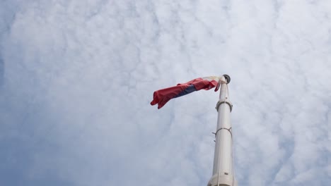 Folded-while-flying-to-the-left-during-a-cloudy-day,-Philippine-Flag