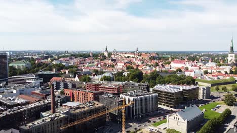 Distance-aerial-view-of-Tallinn-old-town,-modern-cityscape-in-foreground