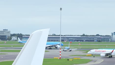 Slowmotion-shot-of-an-airplane-taking-off-while-others-proceed-over-the-taxi-runways