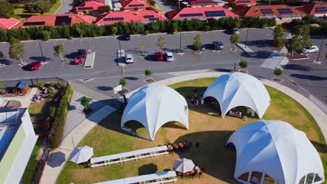 Orbit-view-over-white-dome-tents-and-picnic-benches-setup-ready-for-outdoor-event