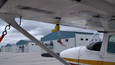 Remove-Before-Flight-Tag-On-Aircraft-Wing-Blown-By-The-Wind-At-The-Airport
