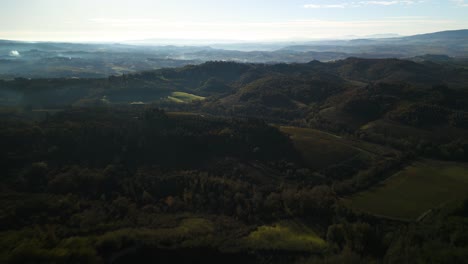 Fast-aerial-dolly-above-rolling-Tuscan-hills-and-mountains-layered-with-misty-fog