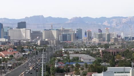 Aerial-of-the-Las-Vegas-Strip-during-day-time,-rising-drone-shot-of-the-street-and-skyline