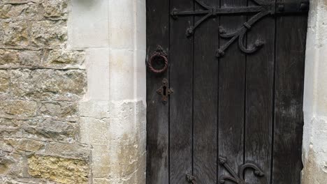 Antique-Black-Wooden-Door-Of-Holy-Trinity-Church-In-Headington-Quarry,-Oxfordshire,-England