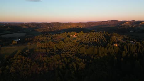 Golden-hour-glow-spreads-across-villa-overlooking-Tuscan-olive-tree-orchards