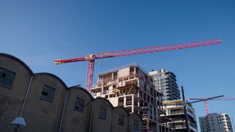 A-tall-crane-working-on-new-apartment-buildings-under-the-clear-blue-sky