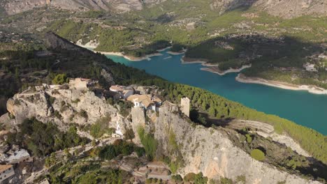 Drohne-Kreist-über-Der-Burg-Von-Guadalest-Und-Hinter-Dem-Blauen-See