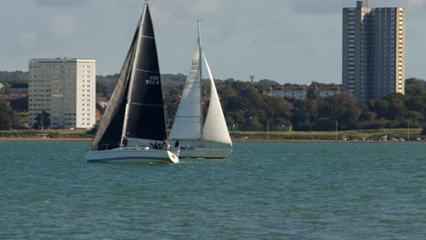 Zwei-Segelboote-Kreuzen-Sich-Auf-Dem-Solent-In-Southampton-Mit-Weston-Im-Hintergrund