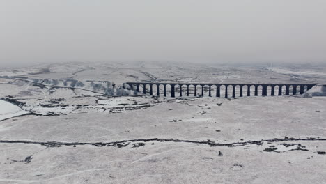 Fast-Establishing-Wide-Angle-Aerial-Drone-Shot-of-Ribblehead-Viaduct-in-Snowy-Yorkshire-Dales-UK