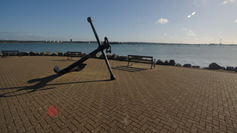 extra-wide-shot-of-an-old-anchor-at-Hythe-Marina-village-with-Weston-in-background