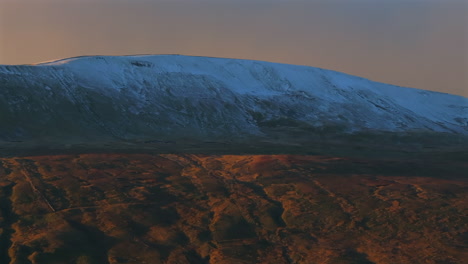 Long-Lens-Closeup-Aerial-Drone-Shot-of-Snowy-Whernside-Mountain-at-Sunset-Golden-Hour-Yorkshire-Dales-UK