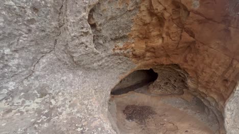 Salir-A-Pie-Desde-El-Interior-De-La-Cueva,-Superficie-Pedregosa-Y-Rocosa-De-Una-Estructura-Antigua,-Ambiente-Natural-Crudo