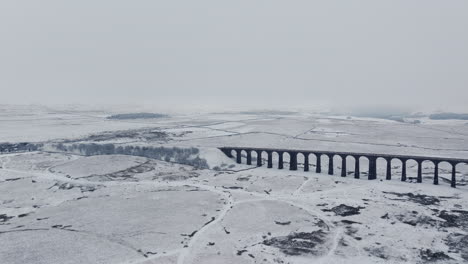 Weitwinkelaufnahme-Einer-Luftdrohnenaufnahme-Des-Verschneiten-Ribblehead-Viadukts-An-Einem-Nebligen-Tag-In-Yorkshire-Dales,-Großbritannien