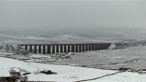 Establishing-Aerial-Drone-Shot-of-Snowy-and-Gloomy-Ribblehead-Viaduct-in-Yorkshire-Dales-UK