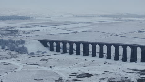 Establishing-Aerial-Drone-Shot-of-Snowy-Ribblehead-Viaduct-on-Misty-Day-in-Yorkshire-Dales-UK