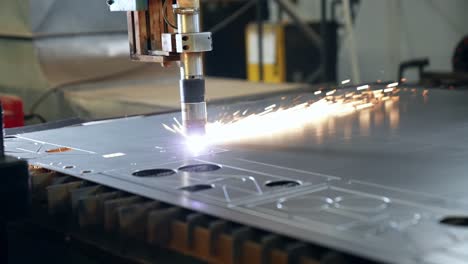 industrial-laser-cutter-cutting-figures-in-a-sheet-of-steel-while-sparks-fly-in-slow-motion