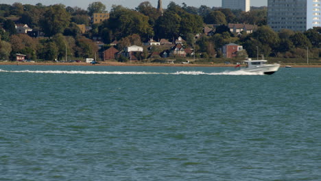 motor-yacht-goes-fast-through-the-frame-at-the-Solent-Southampton-with-Weston-in-background