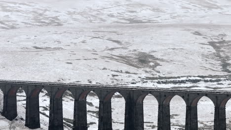 Long-Lens-Establishing-Aerial-Drone-Shot-of-Ribblehead-Viaduct-in-Snowy-Yorkshire-Dales-UK