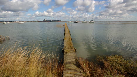 extra-wide-mid-shot-of-a-long-wooden-jetty-with-flooding-debris-on-top