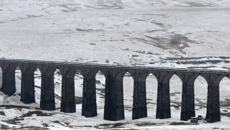 Long-Lens-Aerial-Drone-Shot-of-Snowy-Ribblehead-Viaduct-in-Winter-Yorkshire-Dales-UK